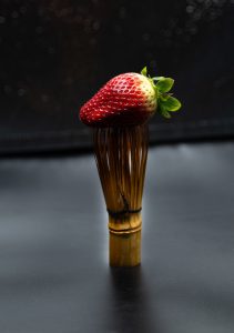 a strawberry sitting on top of a wooden stick